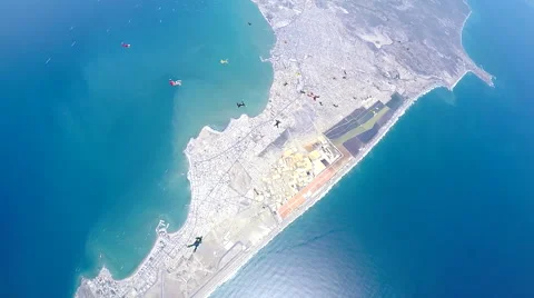 Group of skydivers are hovering in accelerated free fall above coastal city Video stock 60841424