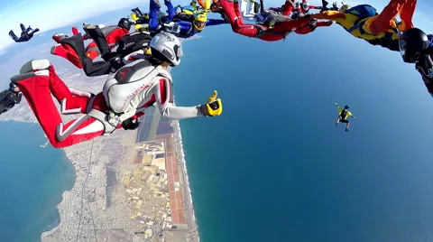 Group of skydivers are hovering in accelerated free fall above coastal city Video stock 60843044