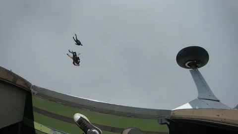 Group of Skydivers Exit the Plane and Soar Through the Grey Sky Stock Footage 208738370