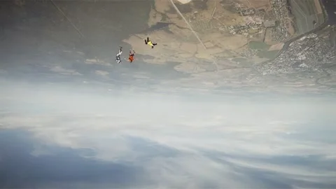 Group of skydivers flying in sky above flatland, river. Extreme sport. Landscape Stock Footage 152065082