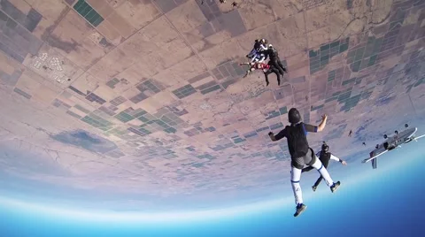 Group of skydivers make formation in blue sky. Open parachute above arizona Stock Footage 68897530