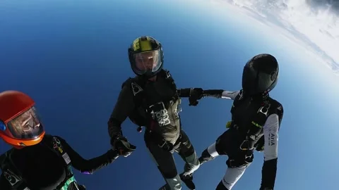 Group of skydivers make formation in cloudy sky. Extreme sport. Holding hands. Vidéo 151346346