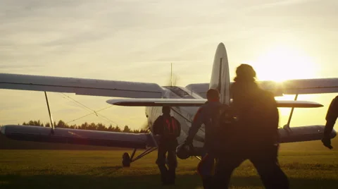 Group of Skydivers Moving Towards Airplane in Sunset Light Stock Footage 54382425