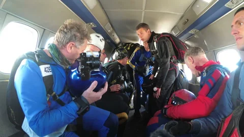 Group of skydivers sits inside a small plane awaiting a jump. Slow Motion Stock Footage 96534916