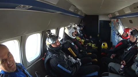 Group of skydivers sits inside a small plane awaiting a jump Stock Footage 96578267