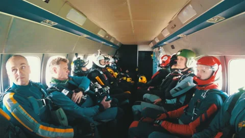 Group of skydivers sits inside a small plane awaiting a jump. Slow Motion Stock Footage 96606650