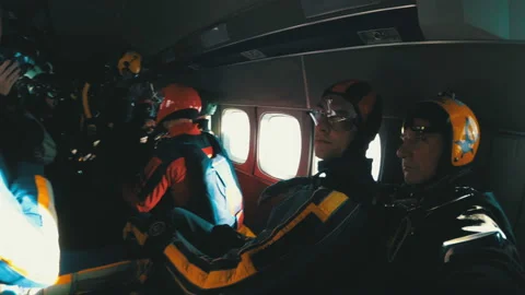 Group of skydivers sits inside a small plane awaiting a jump. Slow Motion Stock Footage 96608309