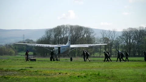 A group of skydivers walk to plane on end of runway ready for skydiving. Vidéo 156163397
