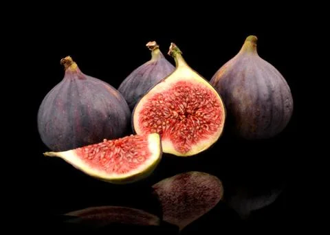 Group sliced figs lengthwise in half and quarter, isolated on black backgroun Stock Photos