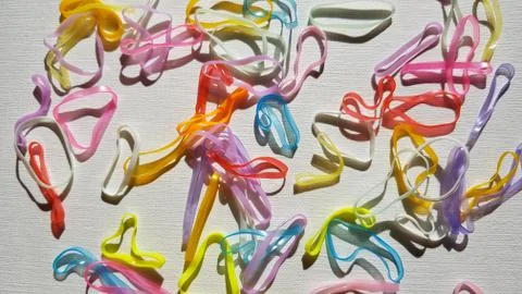 Group of small multi-colored elastic bands for hair on a white table. 库存照片