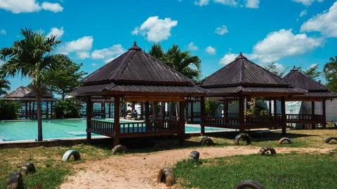 A group of small wooden structures with a pool in the background Stock Photos