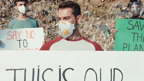 Group of smart guys in protective masks holding invocatory posters to save Stock Footage 113924809