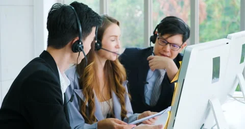 Group of smiling customer service agent wearing headset with colleagues working Stock Footage 147111467