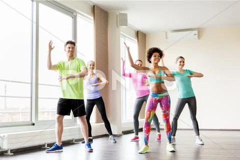 Group of smiling people dancing in gym or studio Stock Photos