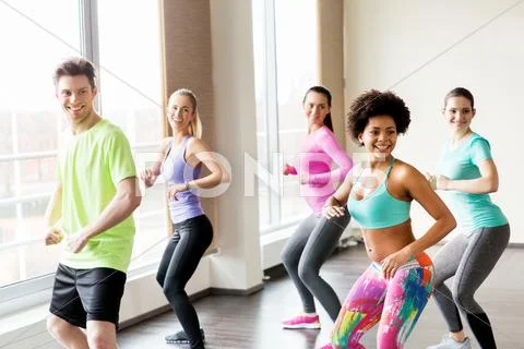 Group of smiling people dancing in gym or studio Stock Photos