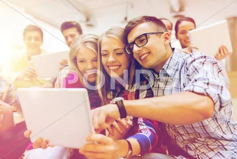 Group of smiling students with tablet pc Stock Photos