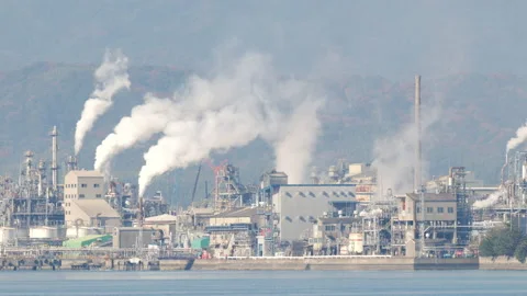 A Group of Smoking Chimneys in a Plat Facing a Bay (Panning) Stock Footage 169242374