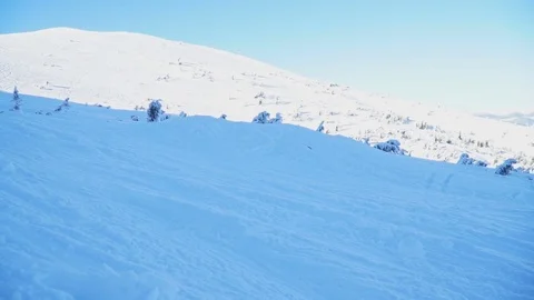 A group of snowboarders jumping on a mountainside in the winter Stock Footage