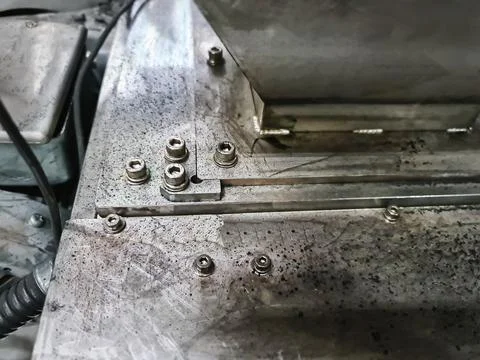 Group of Socket Head Screws Fastened on Dirty Machine Base Foto stock