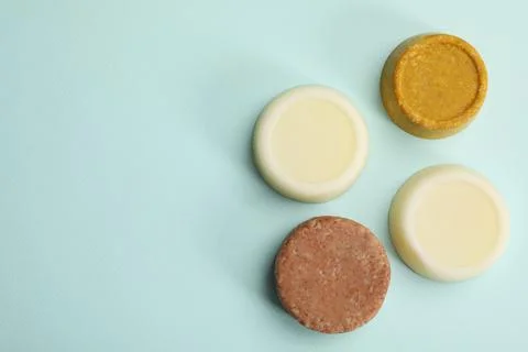 Group of solid shampoo bars on turquoise background, flat lay. Space for text 写真素材