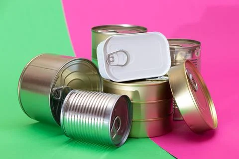 A Group of Stacked Tin Cans on Split Green and Cyan Background Foto stock