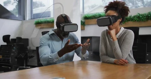 Group strapping VR headsets at meeting table and pointing and resizing model for Video stock 330664799