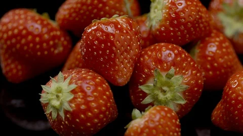 A group of strawberries rotating on a black background 動画素材 128694019