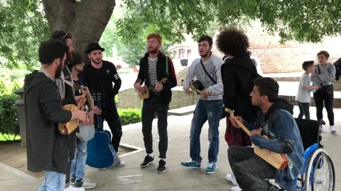 A group of street musicians play musical instruments and sing songs. Stock Footage