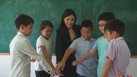 Group of students and teacher putting hands together and cheering up Stock Footage 90274971