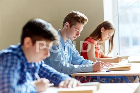Group of students with books writing school test Stock Photos