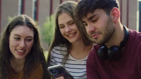 Group of students browsing phone next to to university campus Stock-Footage 245431756