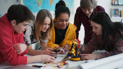 Group of students building and programming electric toys and robots at robotics Stock Footage 197431342