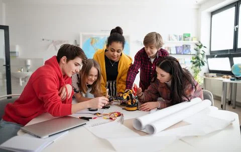 Group of students building and programming electric toys and robots at robotics Stock Photos