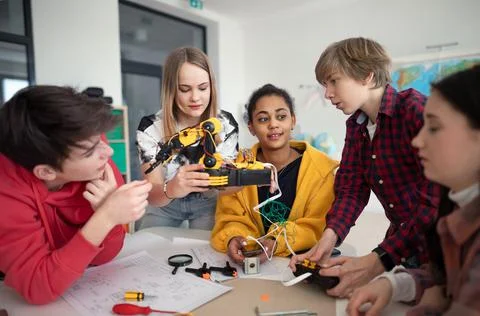 Group of students building and programming electric toys and robots at robotics Foto stock