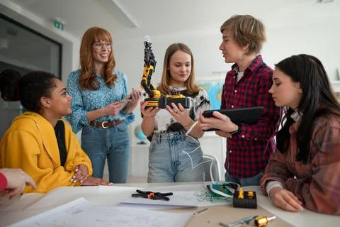Group of students building and programming electric toys and robots at robotics Stock Photos