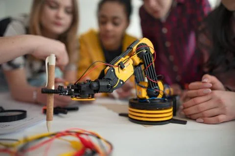 Group of students building and programming electric toys and robots at robotics Stock Photos