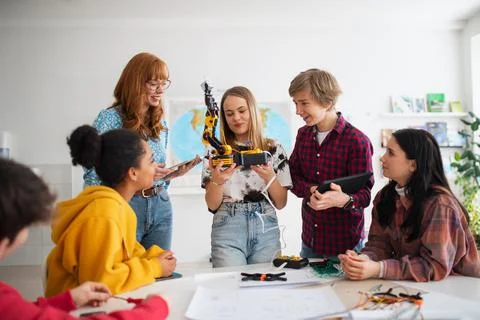 Group of students building and programming electric toys and robots at robotics Foto stock