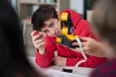Group of students building and programming electric toys and robots at robotics Stock Photos
