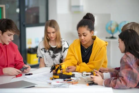 Group of students building and programming electric toys and robots at robotics Stock Photos