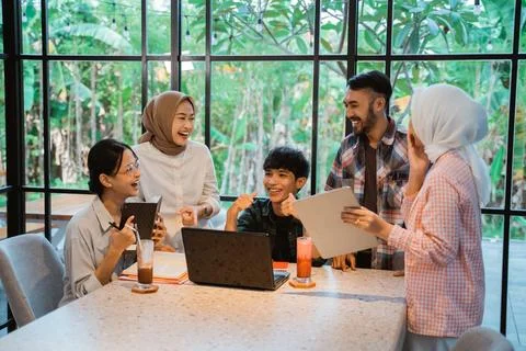 Group of students chatting while working on assignments together Stock Photos