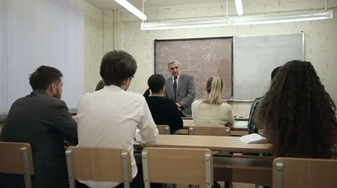 Group of students in a classroom, listening as their teacher holds a lecture. Stock Footage 44233225