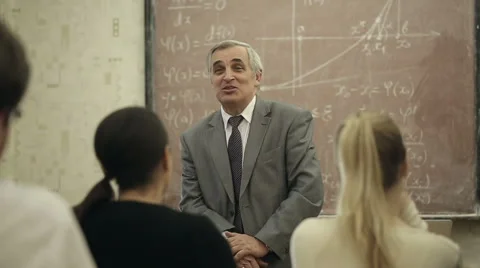 Group of students in a classroom, listening as their teacher holds a lecture. Stock Footage 44233368