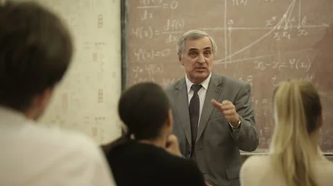 Group of students in a classroom, listening as their teacher holds a lecture. Stock Footage 44234506