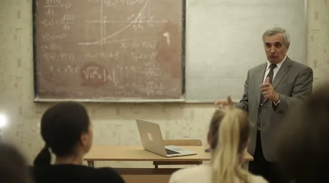 Group of students in a classroom, listening as their teacher holds a lecture. Stock Footage 44234770