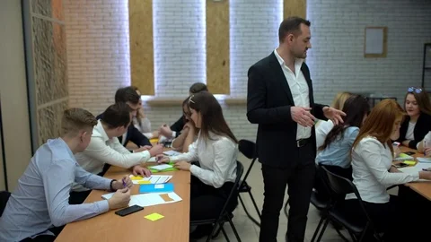 Group of students in a classroom, listening as their teacher holds a lecture. 4 Stock Footage 85042810