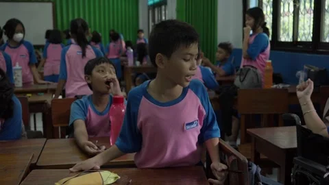 Group of students in classroom setting interacting and learning together at Stock Footage 310320722