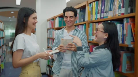 Group of students discussing and gathering information, for a report in library. Vídeos de archivo 329401289