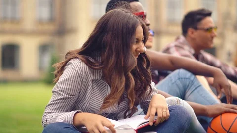 Group of students have fun after classes on the lawn at campus Stock Footage 130049045
