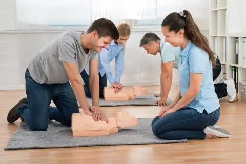 Group Of Students Learning Cpr On Dummy In Class Foto stock