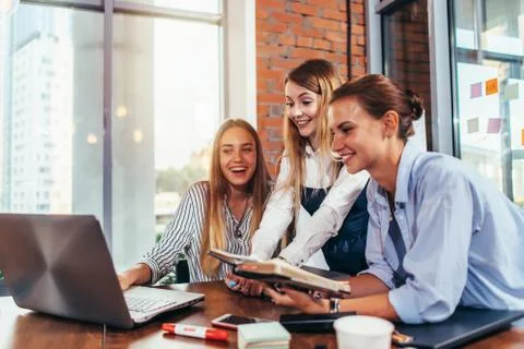 Group of students looking at laptop taking a break after studying in college 스톡 사진